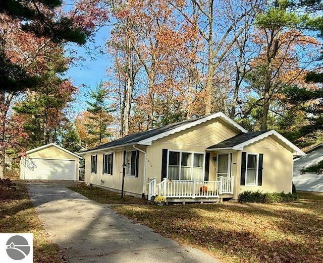 single story home featuring an outbuilding, a garage, and a porch