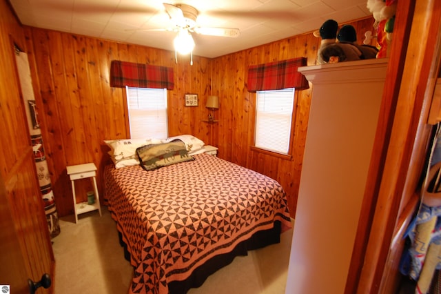 bedroom with wood walls, ceiling fan, and carpet floors