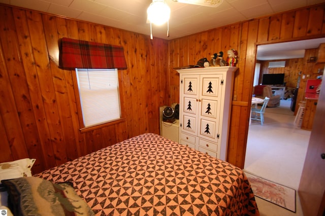 carpeted bedroom featuring wooden walls