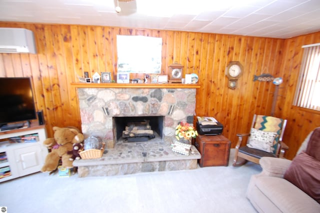 carpeted living room featuring wood walls, a wall unit AC, a stone fireplace, and a wealth of natural light