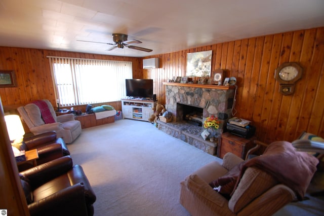 living room featuring a stone fireplace, wooden walls, ceiling fan, and a wall mounted air conditioner