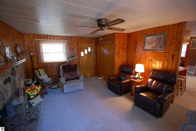 living room featuring wood walls, carpet, and ceiling fan