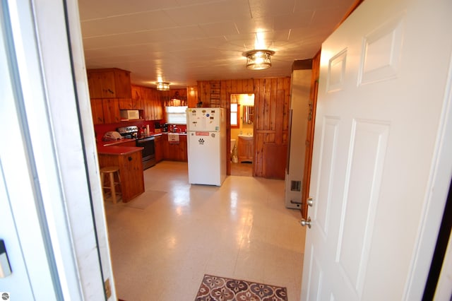 kitchen with white appliances and wooden walls