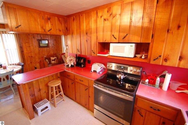 kitchen featuring electric stove and wooden walls