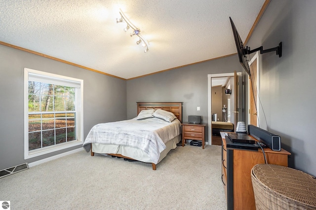 bedroom featuring light colored carpet, a textured ceiling, crown molding, and vaulted ceiling