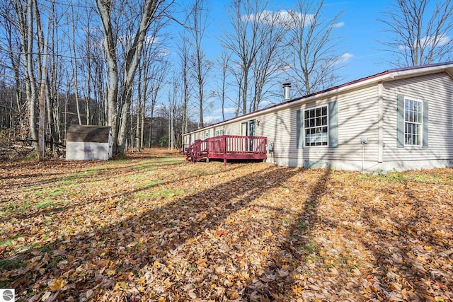 view of home's exterior with a deck and a storage shed