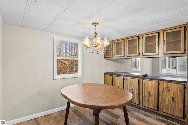 dining room with hardwood / wood-style floors, a chandelier, and a textured ceiling