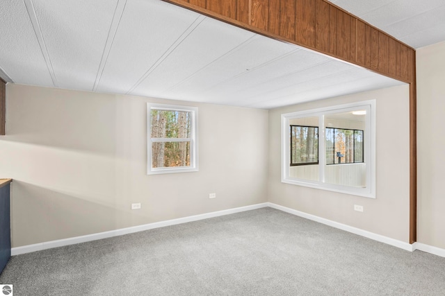 carpeted empty room featuring a textured ceiling