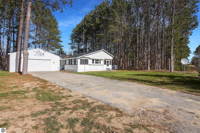 ranch-style house featuring a front lawn, a garage, and an outdoor structure