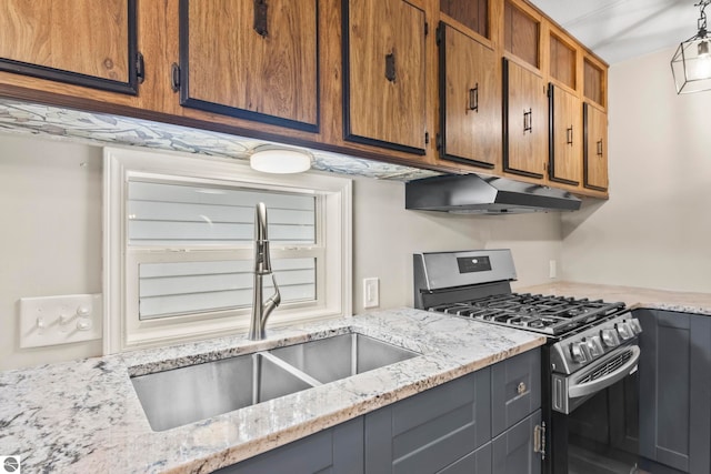 kitchen featuring light stone countertops, sink, and gas stove