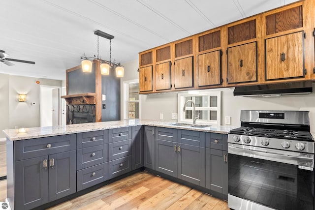 kitchen with kitchen peninsula, light hardwood / wood-style flooring, gas range, and sink