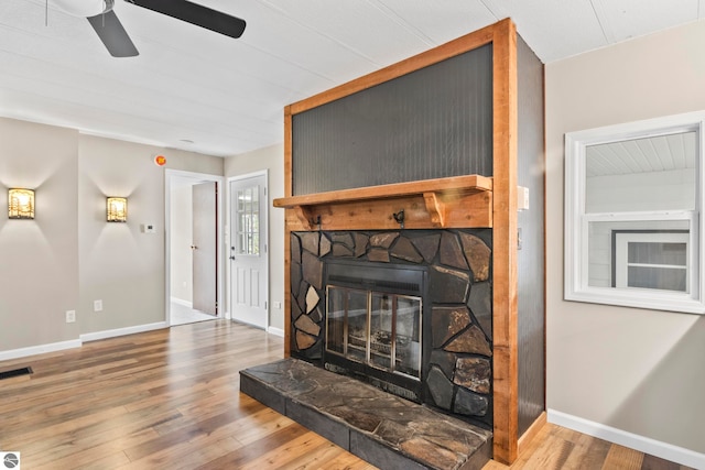 details with a stone fireplace, hardwood / wood-style flooring, and ceiling fan