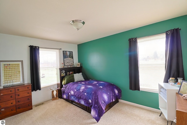 carpeted bedroom with multiple windows