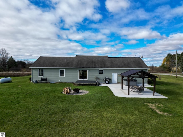 rear view of property featuring a fire pit, a lawn, a patio area, and a gazebo