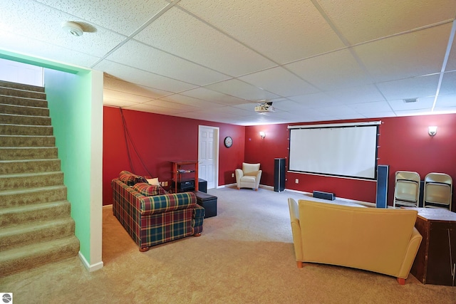 carpeted cinema room featuring a drop ceiling