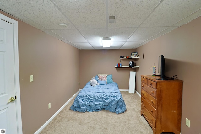 carpeted bedroom with a drop ceiling