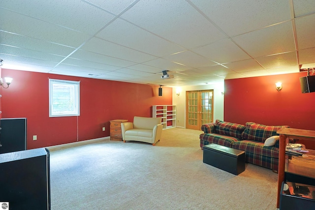 carpeted living room with a drop ceiling and french doors