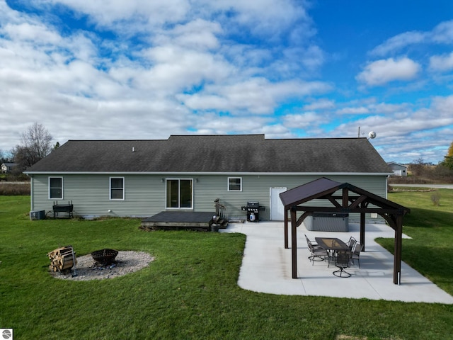 rear view of property with a patio, a yard, a fire pit, and a gazebo