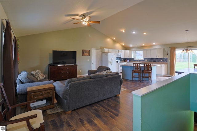 living room featuring ceiling fan with notable chandelier, dark hardwood / wood-style flooring, lofted ceiling, and sink