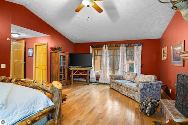 bedroom with ceiling fan, wood-type flooring, a textured ceiling, and lofted ceiling