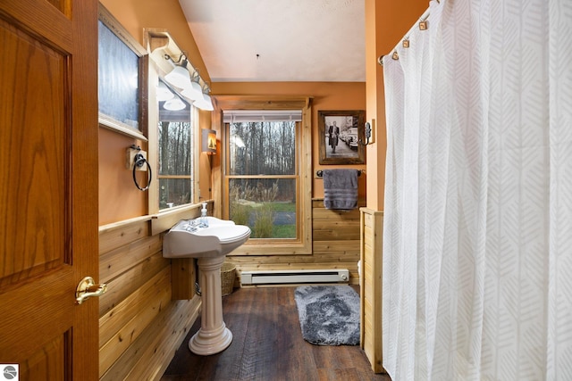 bathroom featuring hardwood / wood-style floors, wood walls, and a baseboard radiator