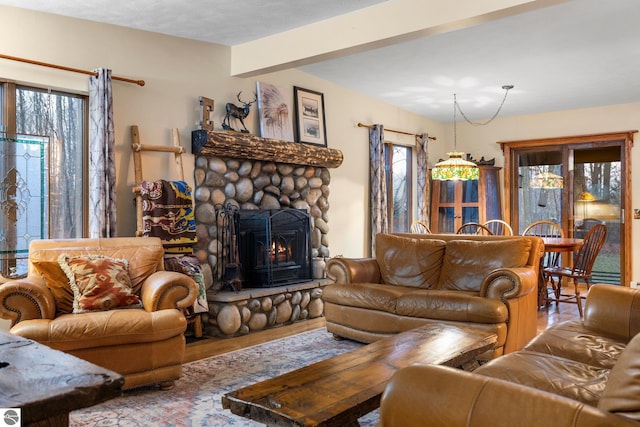 living room featuring beamed ceiling, a wealth of natural light, hardwood / wood-style flooring, and a fireplace