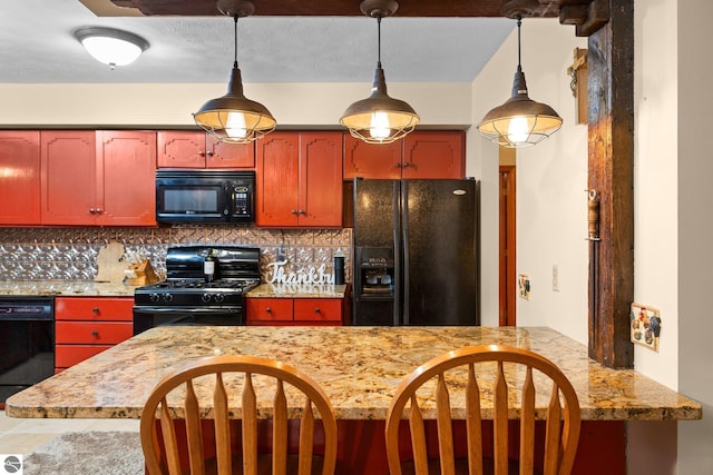 kitchen featuring black appliances, light stone counters, backsplash, decorative light fixtures, and tile patterned floors