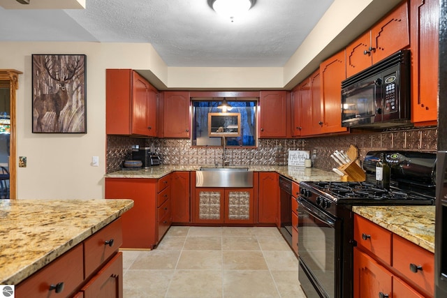 kitchen with sink, black appliances, light stone countertops, a textured ceiling, and decorative backsplash