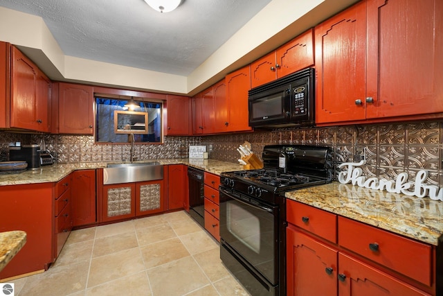 kitchen with black appliances, decorative backsplash, sink, and light stone counters