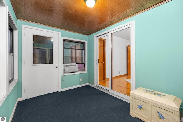 spare room featuring cooling unit, wood ceiling, and dark carpet