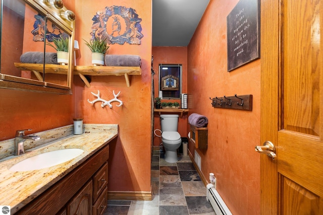 bathroom with baseboard heating, vanity, and toilet