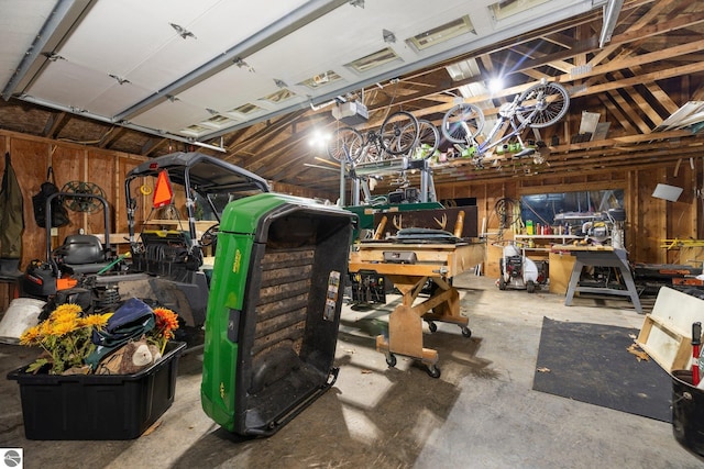 garage with a garage door opener, wood walls, and a workshop area