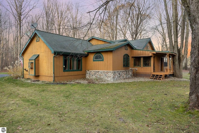 back house at dusk with a lawn