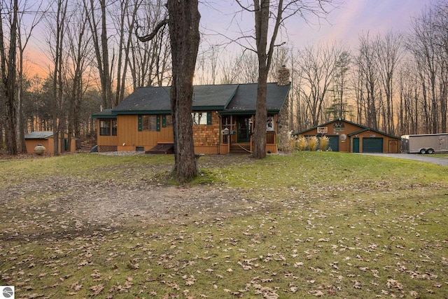 ranch-style house featuring an outbuilding, a garage, and a yard