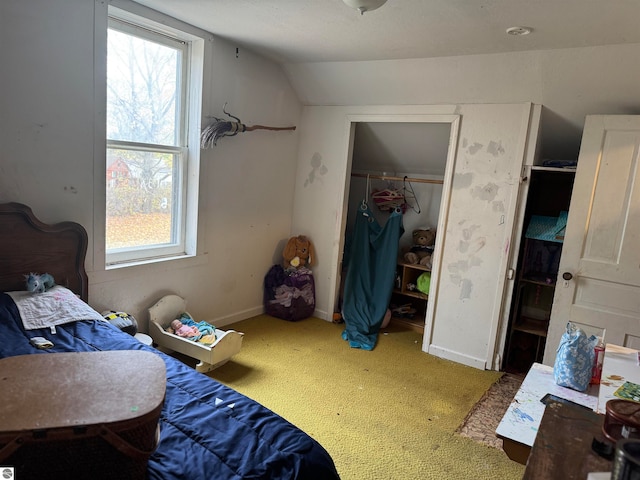 bedroom with carpet flooring, multiple windows, a closet, and lofted ceiling