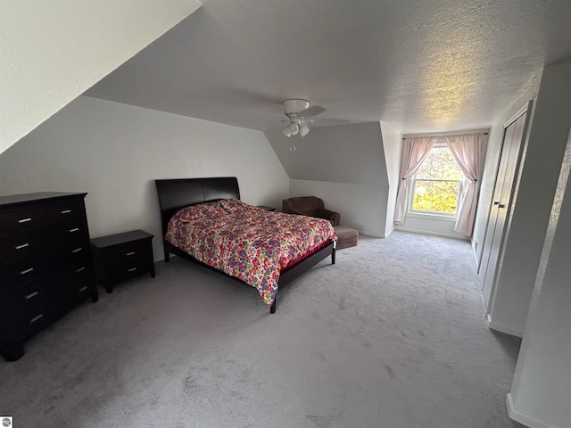 carpeted bedroom featuring a textured ceiling, ceiling fan, and vaulted ceiling