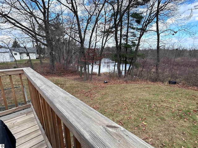 wooden terrace featuring a water view and a lawn