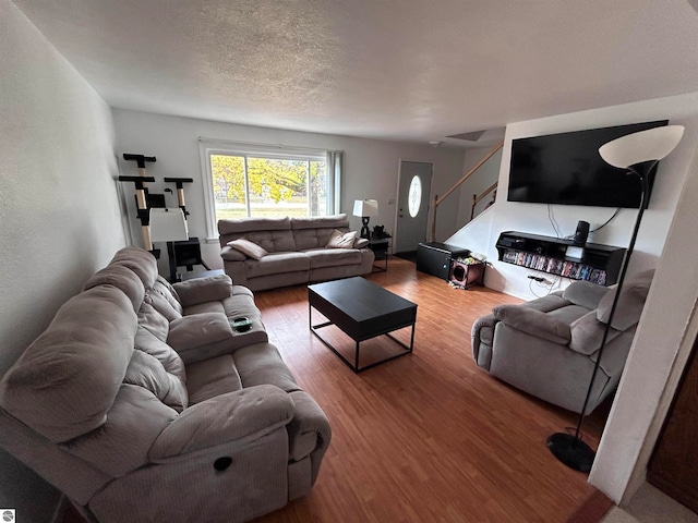 living room with wood-type flooring and a textured ceiling