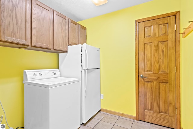 laundry area featuring cabinets, washer / clothes dryer, and light tile patterned flooring