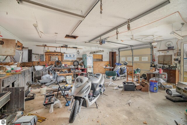 garage featuring a garage door opener, a workshop area, and electric panel