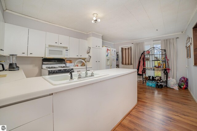 kitchen with dark wood-type flooring, white cabinets, sink, crown molding, and white appliances