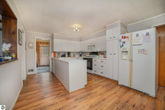 kitchen with ornamental molding, white cabinetry, light wood-type flooring, white appliances, and kitchen peninsula