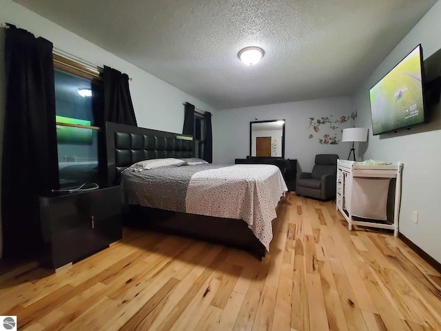 bedroom featuring light hardwood / wood-style floors and a textured ceiling