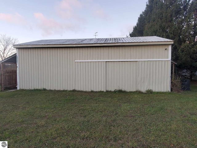 outdoor structure at dusk featuring a yard