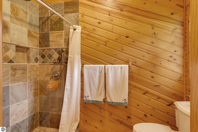 bathroom with a shower with curtain, wooden walls, and toilet