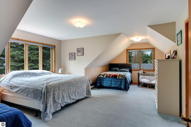 carpeted bedroom with lofted ceiling