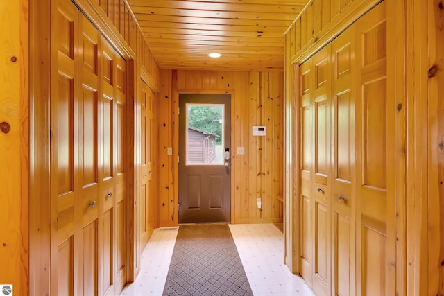 entryway featuring wooden ceiling and wood walls