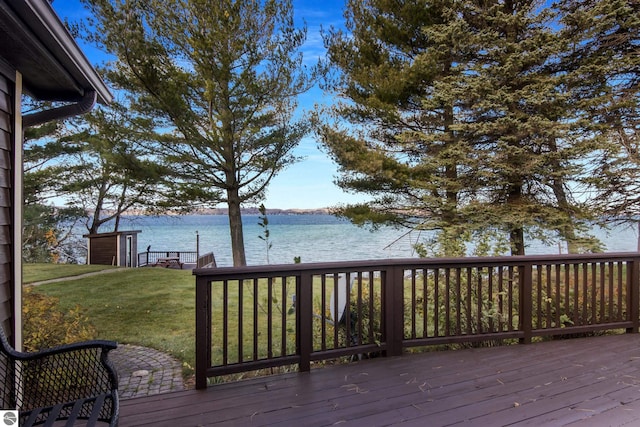 wooden deck featuring a water view and a yard