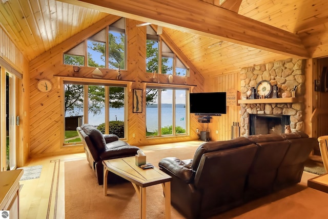 living room with beam ceiling, high vaulted ceiling, wooden walls, a fireplace, and light wood-type flooring