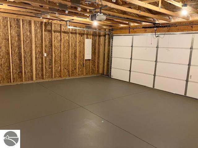 garage featuring electric panel and a garage door opener